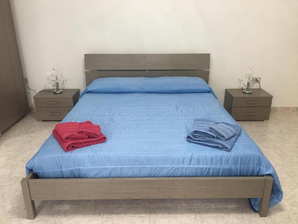 una camera da letto con letto con lenzuola blu e 2 comodini di Casa vacanze One a Frascineto