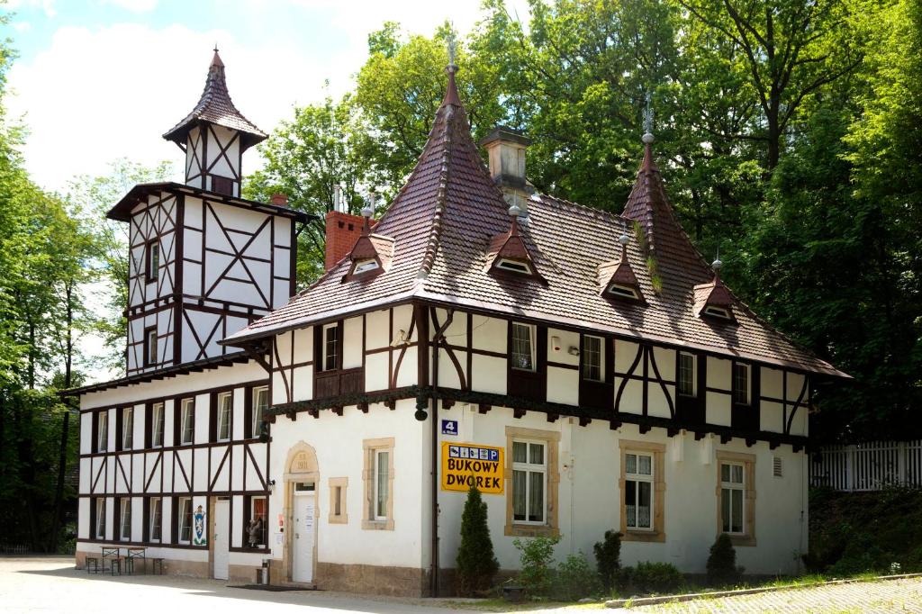 un edificio en blanco y negro con una torre en Bukowy Dworek, en Szczawno-Zdrój