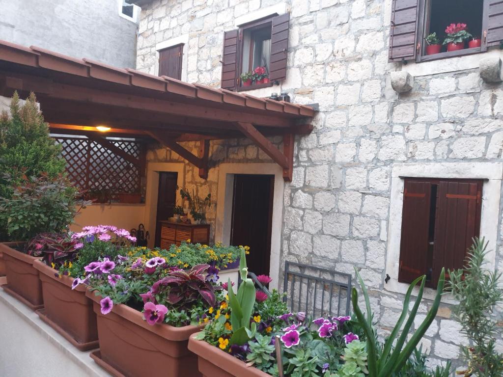 a building with a bunch of flowers in front of it at Apartments and Rooms Villa Lina in Split