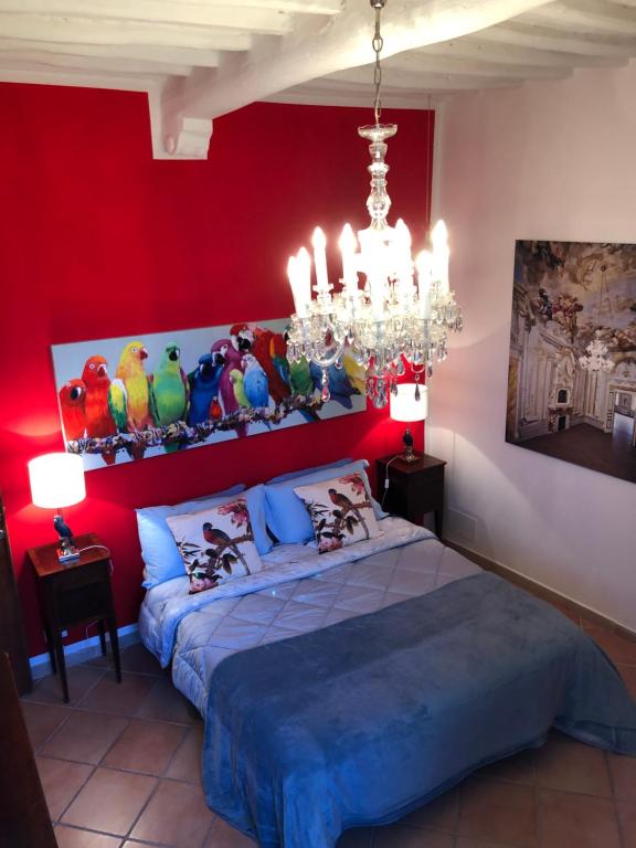 a red bedroom with a bed and a chandelier at Casa Sophia in Siena