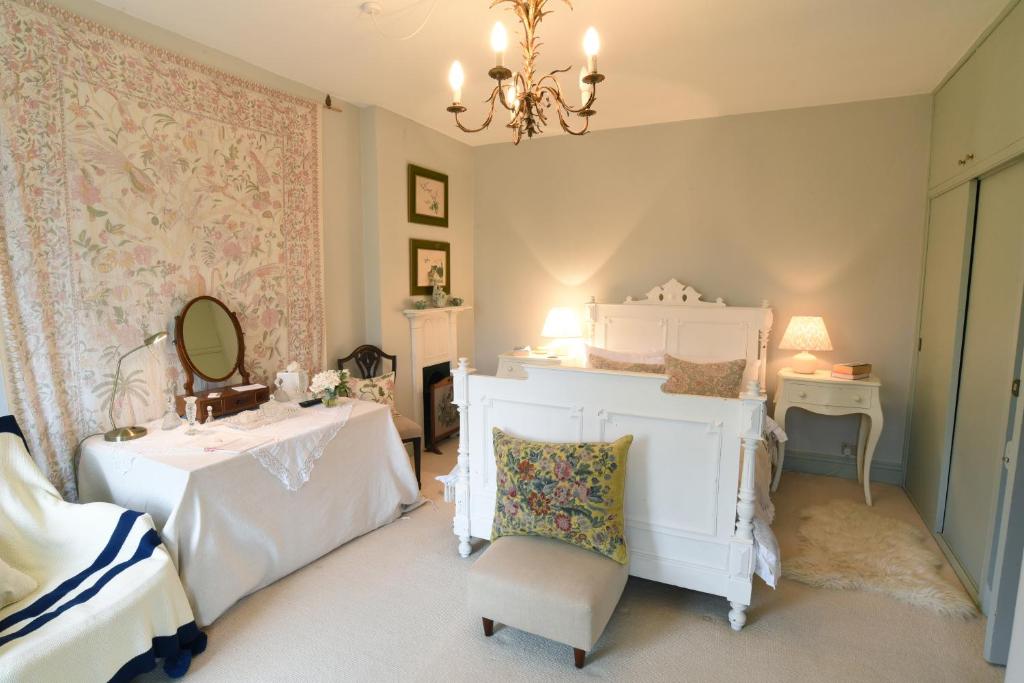a bedroom with two beds and a mirror and a chair at Ellesmere House in Castle Cary