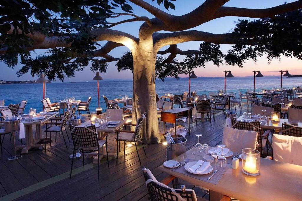 a restaurant with tables and chairs under a tree at Alimos Studio Apartment in Athens