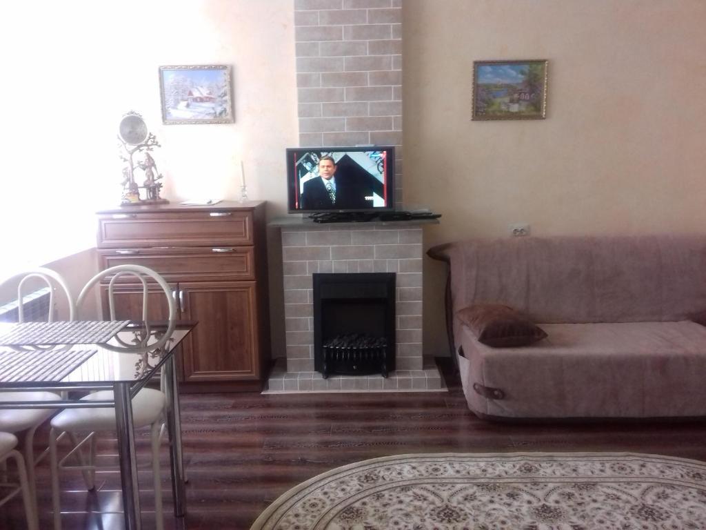 エッセントゥキにあるOrdzhonikidze Street Apartmentのリビングルーム(ソファ、暖炉付)
