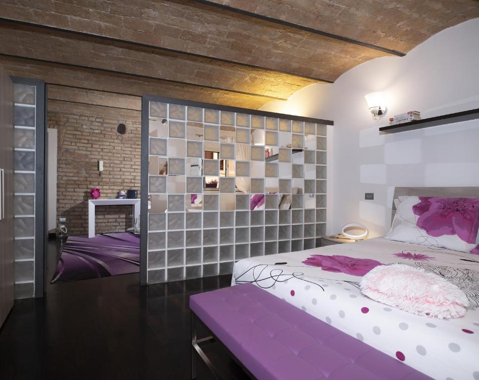 una camera con letto viola e muro di mattoni di Domus Paradiso City Center a Roma