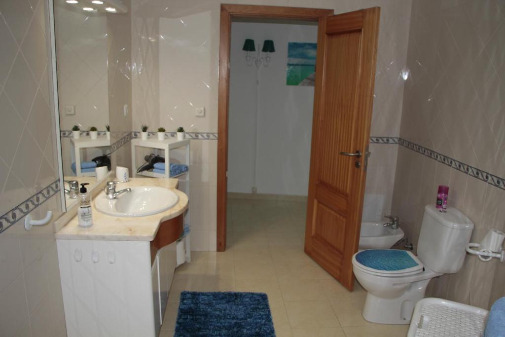 a bathroom with a toilet and a sink and a toilet istg at Ericeira Sunset Apartment in Ericeira