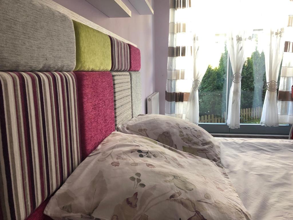 1 cama con edredón y almohadas en Krakowska Apartamenty, en Szczecin