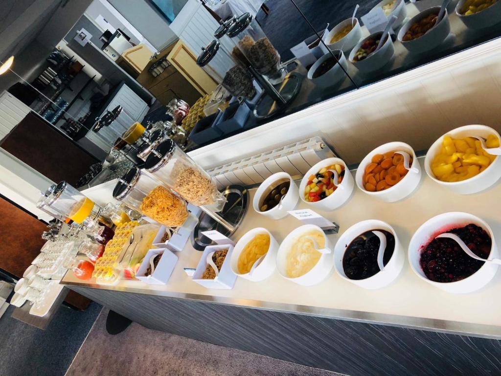 a buffet line with bowls of different types of food at The Pines Hotel in Swanage