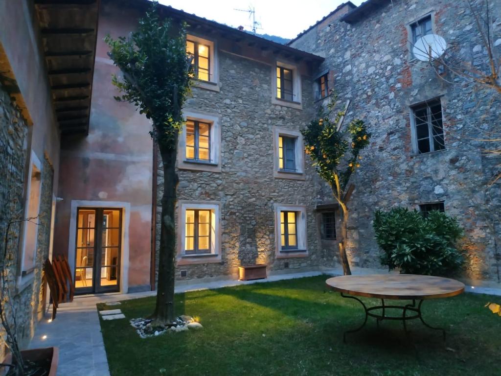 een stenen huis met een tafel in de tuin bij Dimora Carducci in Pietrasanta