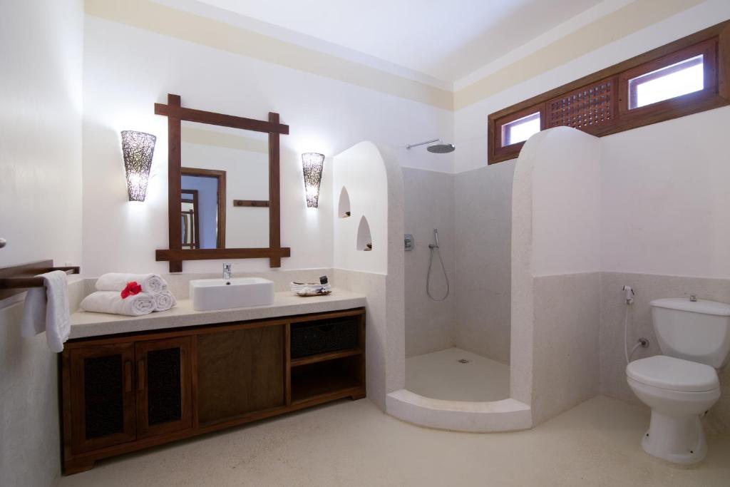a bathroom with a sink and a shower and a toilet at Fruit & Spice Wellness Resort Zanzibar in Kizimkazi