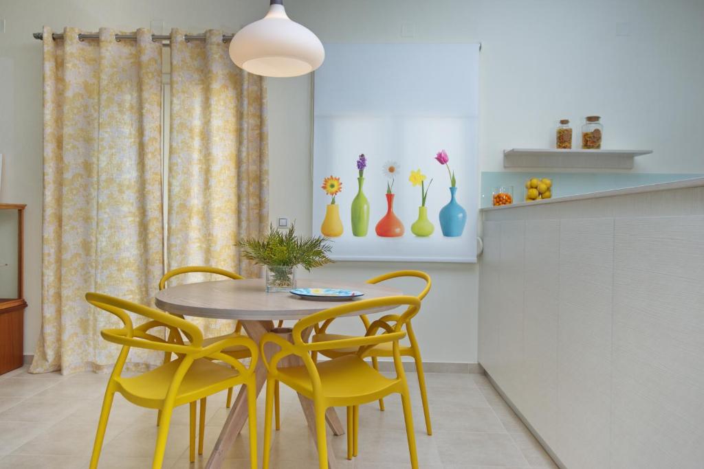 a dining room with a table and yellow chairs at Lidromi Home (Sky) in Patitiri
