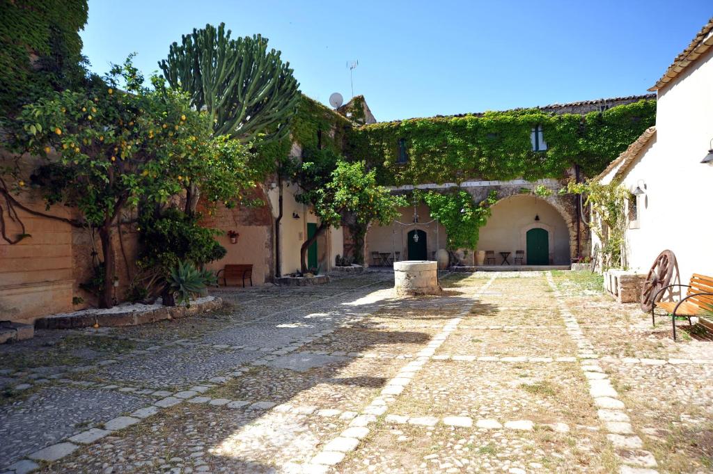 an alley in an old building with ivy at Baglio Siciliamo Country House in Noto Marina