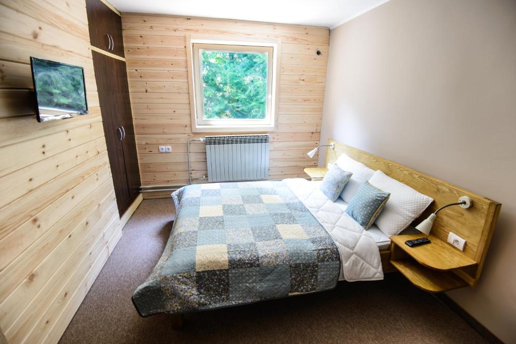 een slaapkamer met een bed en een raam bij Gorski vrt in Novi Sad