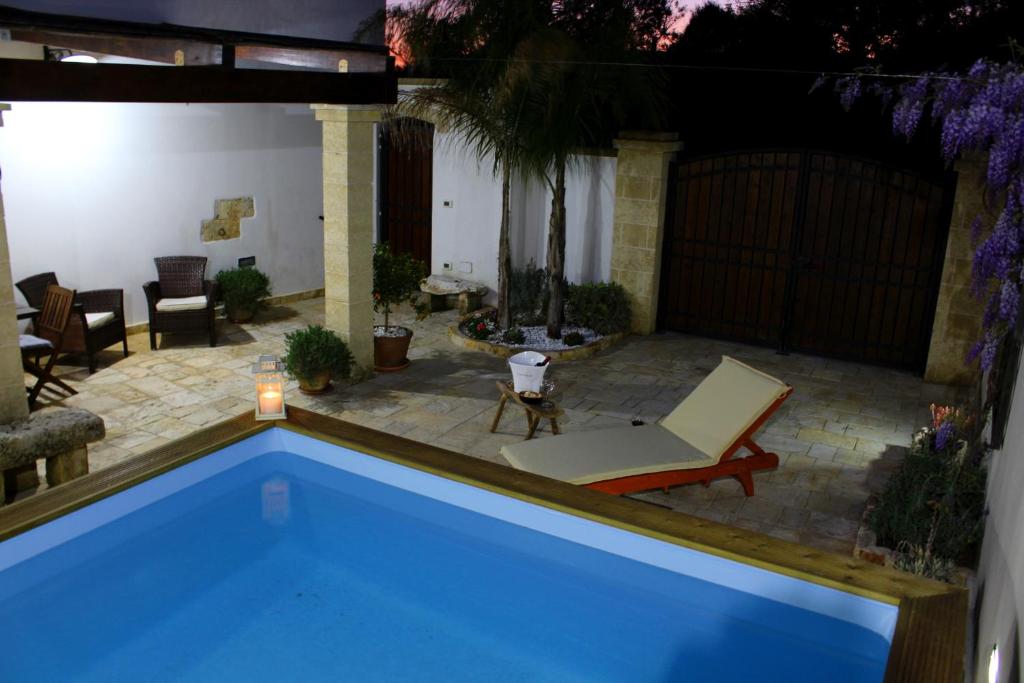 niebieski basen z krzesłem i patio w obiekcie La Casetta di Ciccio w mieście Gagliano del Capo