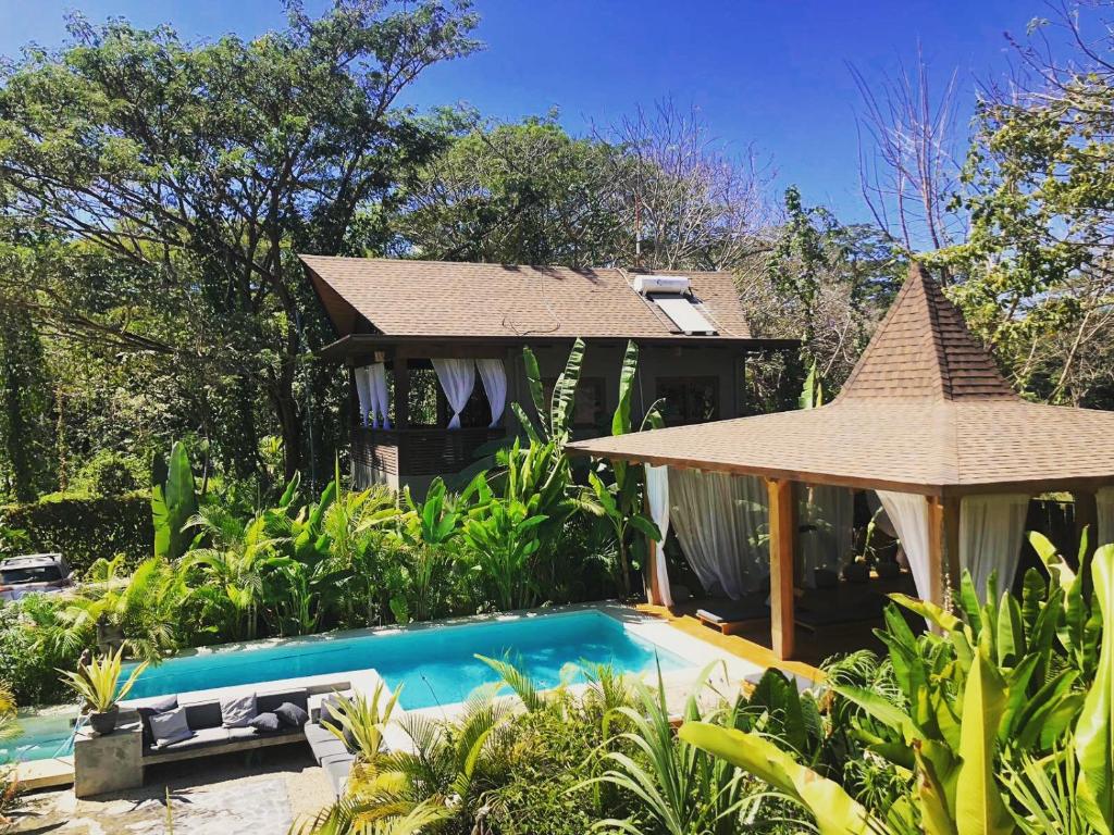 a house with a swimming pool and a gazebo at Lua Villas in Santa Teresa Beach