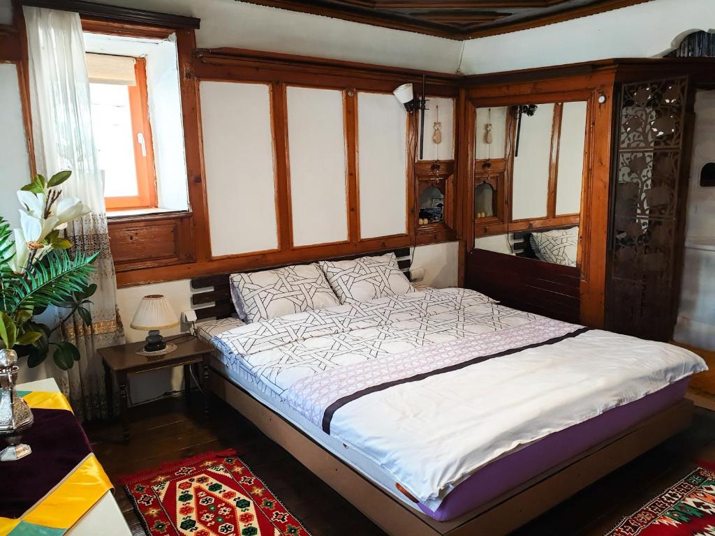 a bedroom with a bed in a room with windows at Kulla Dula Guesthouse in Gjakove