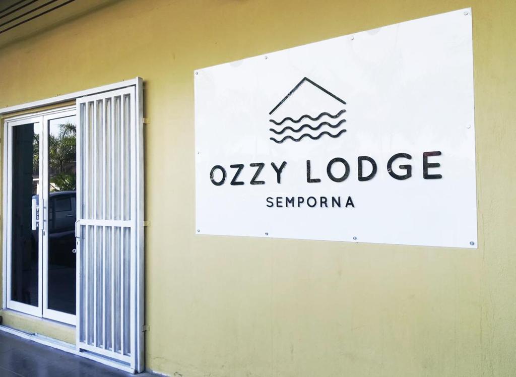 un panneau indiquant le lodge huileux sur le côté d'un bâtiment dans l'établissement Ozzy Lodge Semporna, à Semporna