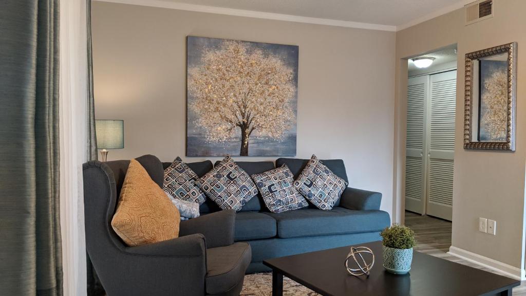 a living room with a blue couch with pillows at Cute Condo in Rock Hill-53 in Rock Hill