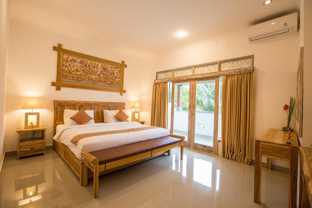 a bedroom with a bed and a large window at Pondok Permata Homestay in Ubud