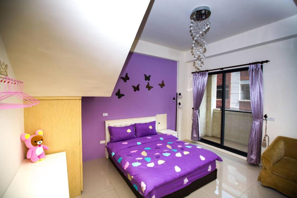a bedroom with a purple bed and a window at Qingyun Homestay in Toucheng