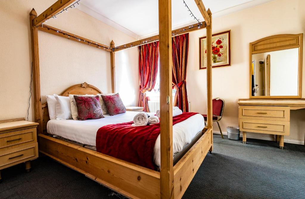 um quarto com uma cama de dossel e um espelho em OYO Paddington House Hotel em Warrington