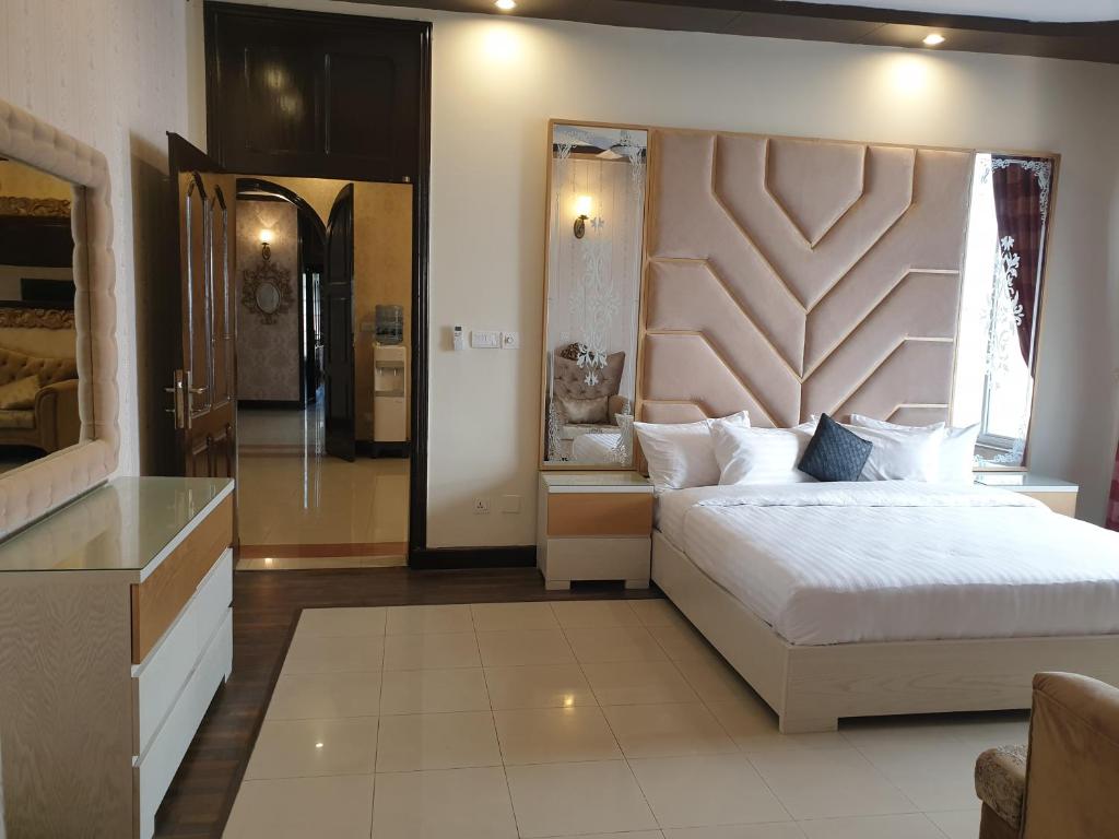 een slaapkamer met een groot bed en een grote spiegel bij Royal Villa F-10/2 in Islamabad