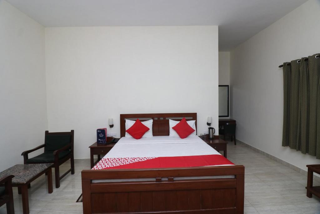a bedroom with a bed with red pillows at Corbett Comfort Lodge in Garjia
