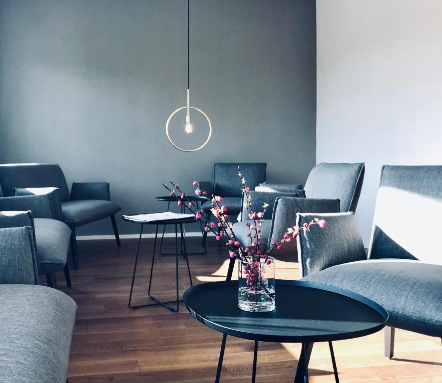 a room with chairs and a table with a vase with flowers at Weingut Gehlen-Cornelius in Brauneberg