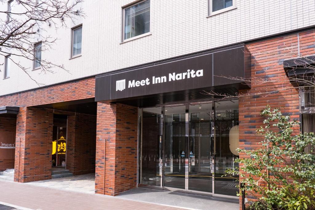 un edificio de ladrillo con una posada nieg en Nederland en Meet Inn Narita, en Narita