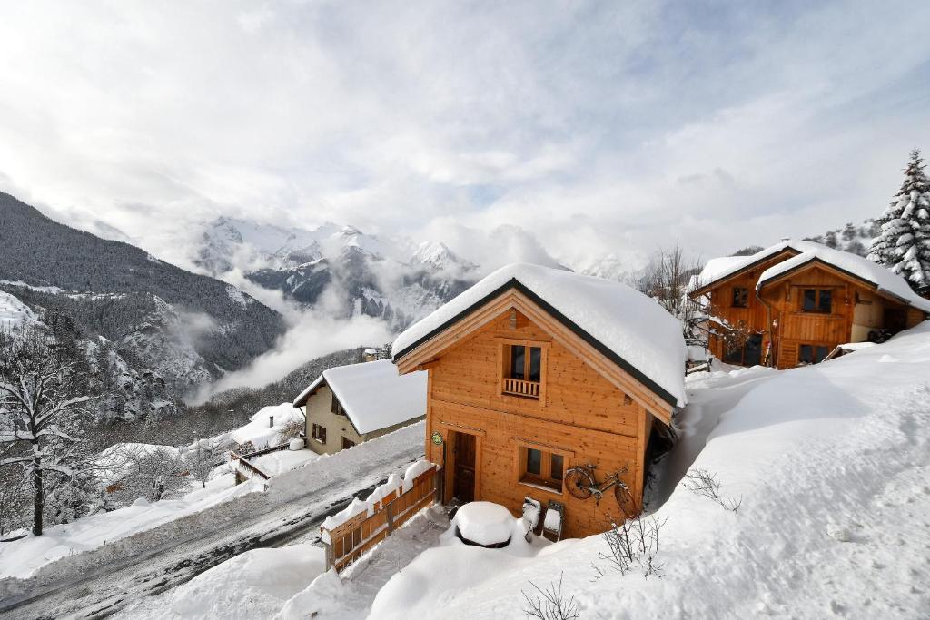 eine Hütte im Schnee mit Bergen im Hintergrund in der Unterkunft chalet perché in Huez