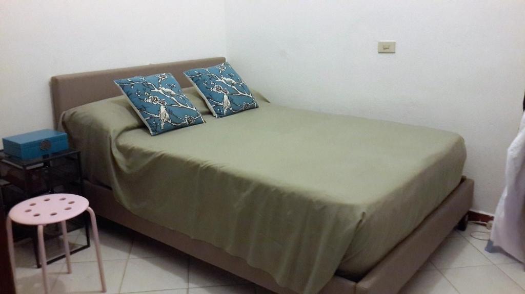 niewielka sypialnia z łóżkiem z niebieskimi poduszkami w obiekcie Apartamento Residencial Costa Azul w mieście Santo Domingo