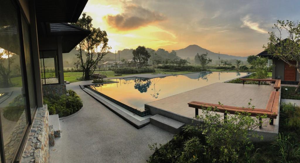 a rendering of a swimming pool with a sunset in the background at At Green Gallery in Si Racha