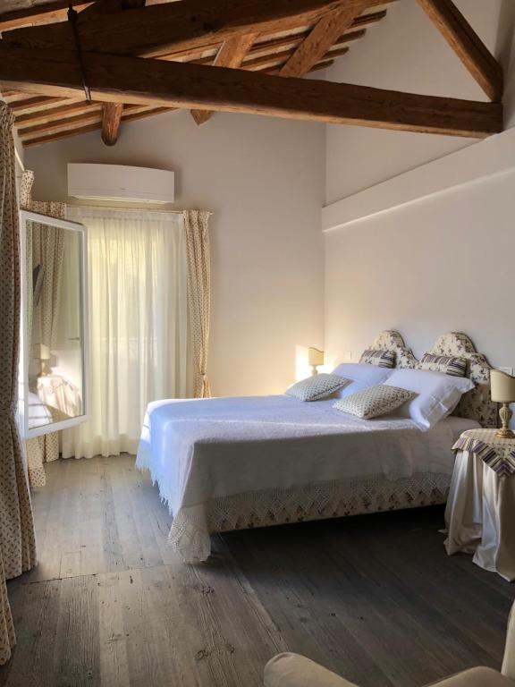 una camera con un letto bianco e una finestra di Le Case Cavour a Ravenna