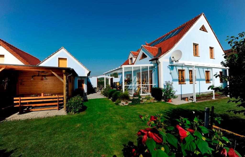 une grande maison blanche avec une cour avec de l'herbe verte dans l'établissement Gästehaus Krappel, à Rohrendorf bei Krems