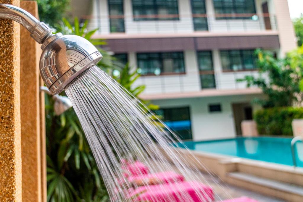 A wall-mounted shower sprays beside the pool.