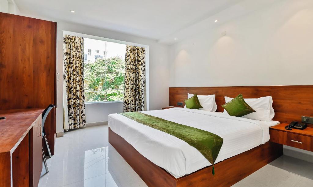 een slaapkamer met een groot bed en een raam bij Treebo Trend Blu Orchid in Bangalore