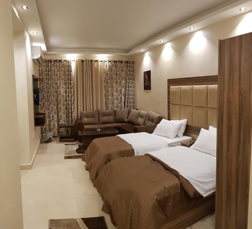 pokój hotelowy z 2 łóżkami i kanapą w obiekcie Marmaris Hotel Apartments w mieście Amman
