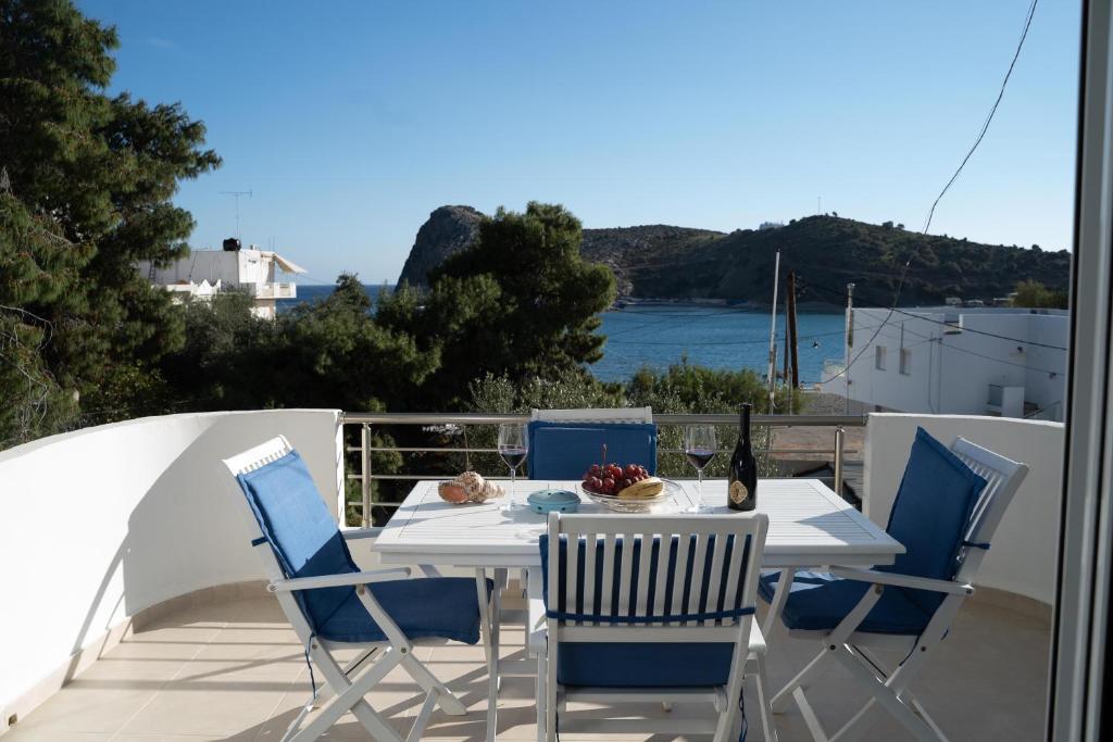 - Balcón con mesa blanca y sillas en Seaside Apartments-Angela, en Kalí Limenes