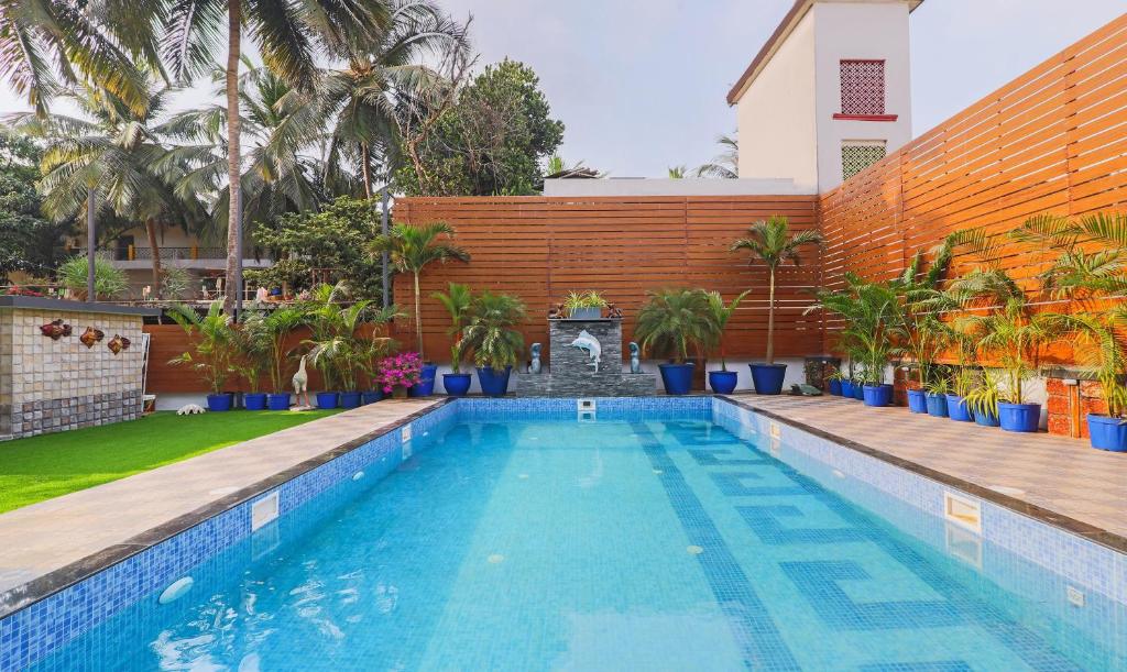 a swimming pool in front of a house at Treebo Trend Dona Eliza 700 metres from Calangute Beach in Calangute