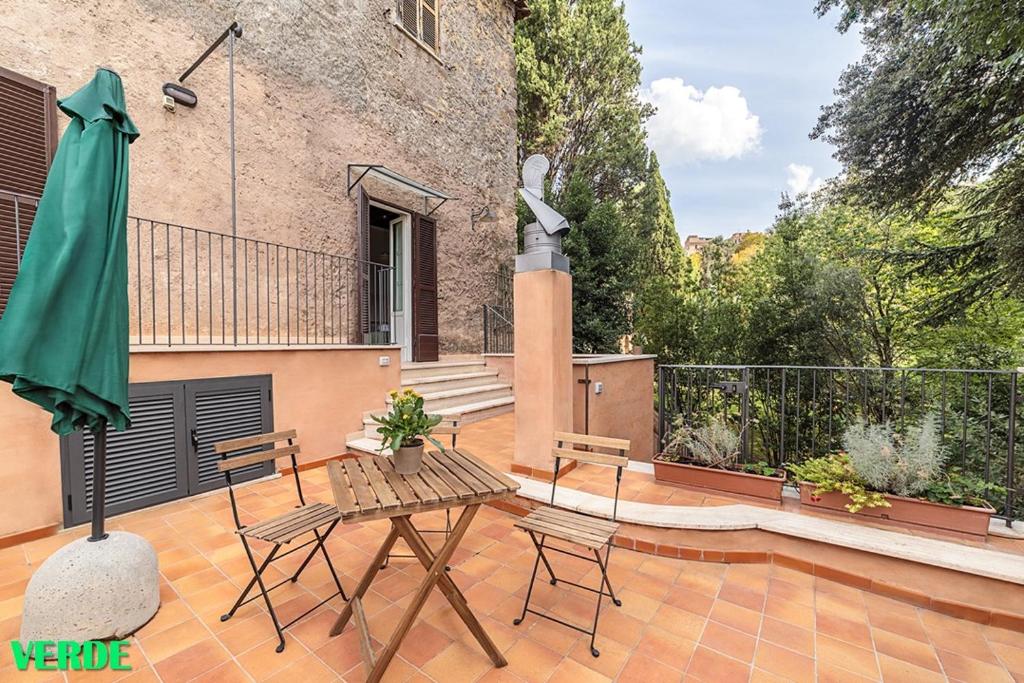 un patio con tavolo, sedie e un edificio di Domus Colonnato su Villa d'Este a Tivoli