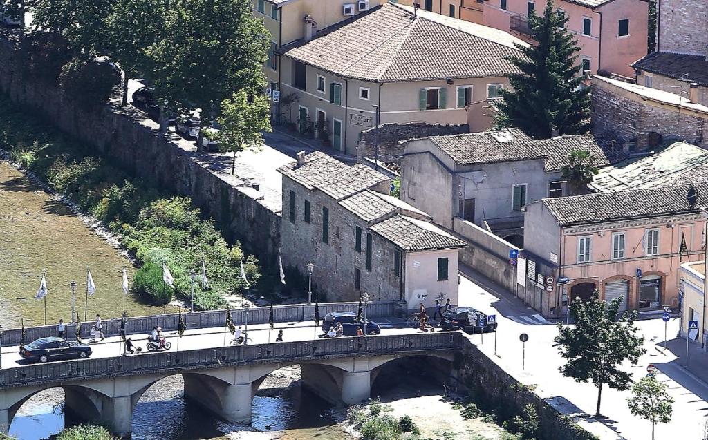 most nad rzeką w mieście z budynkami w obiekcie Hotel Le Mura w mieście Foligno