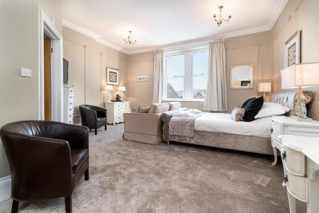 a bedroom with a bed and a desk and a chair at Lansdowne House with Private Car Park in Llandudno