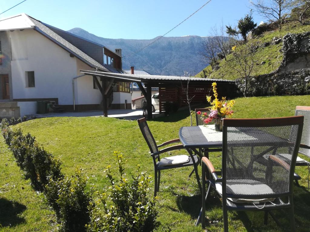 - une table et des chaises dans la cour d'une maison dans l'établissement Apartmaji Pippi, à Bovec