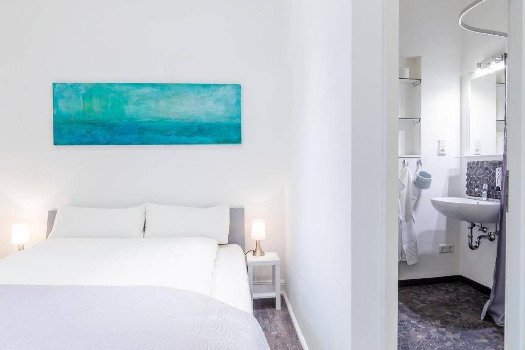 Dormitorio blanco con cama blanca y lavamanos en Apartment 229 en Dortmund