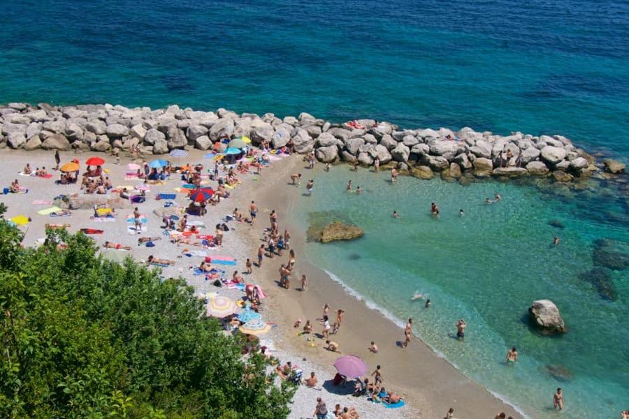 a group of people on a beach near the ocean at Palatium Mari in Capri