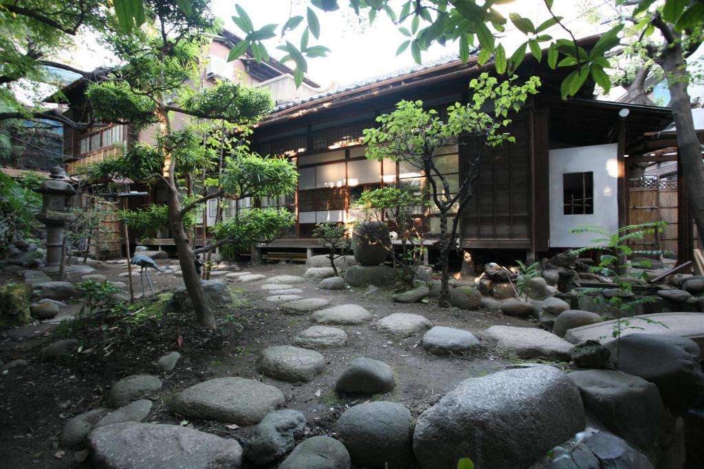 un giardino di fronte a un edificio con rocce di Guesthouse toco a Tokyo
