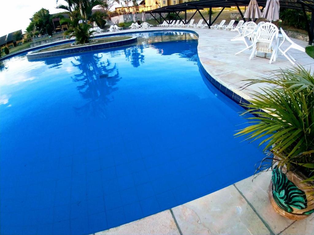 una piscina de agua azul en un complejo en Flat winterwille Gravata, en Gravatá