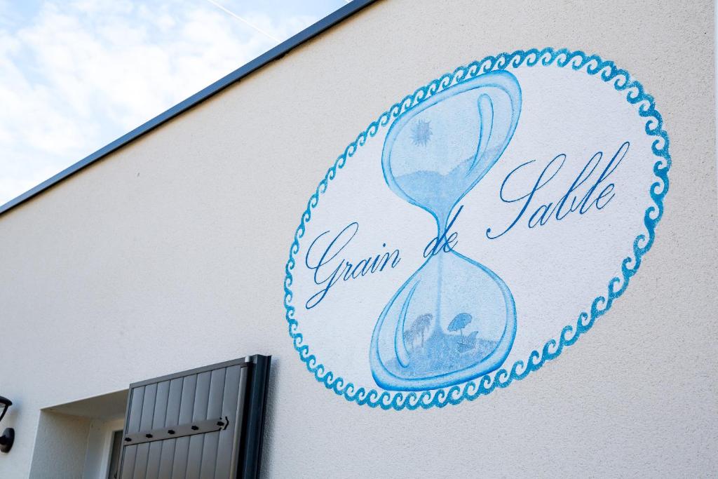 a sign on the side of a building with an hourglass at Grain de Sable et son Jacuzzi in Talmont