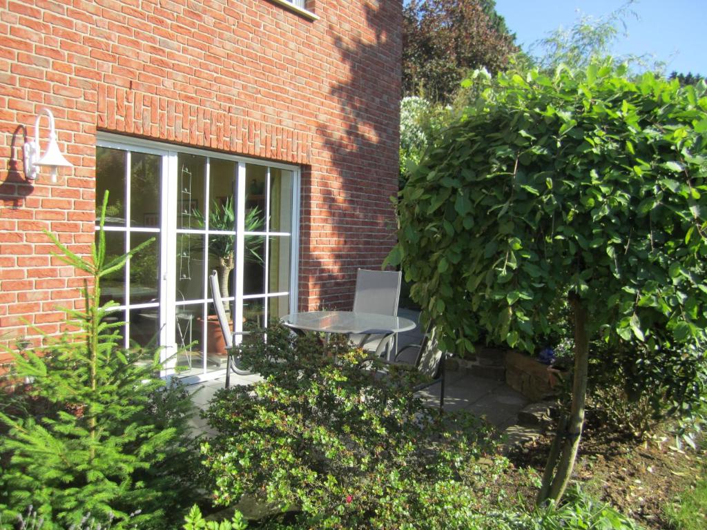 a patio with a table and a window in a brick building at Ferienwohnung Erlenhof in Engelskirchen