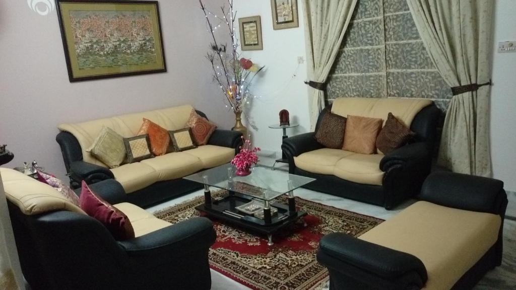 a living room with couches and a glass table at Aadhaar in Lucknow