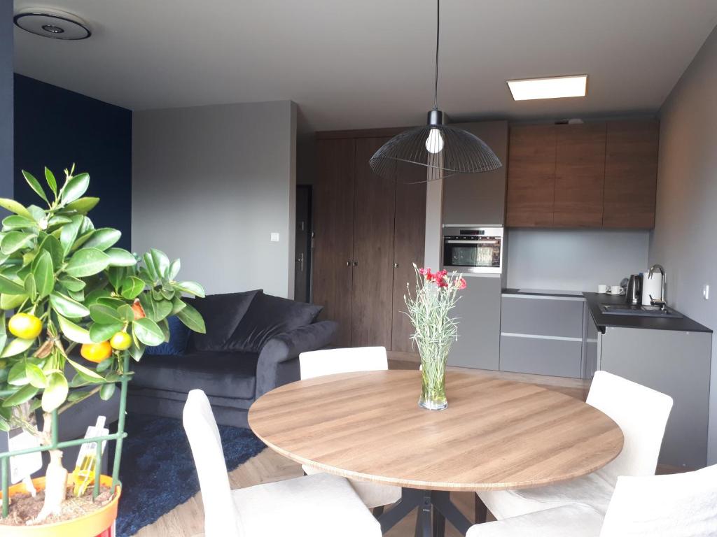 une cuisine et une salle à manger avec une table en bois dans l'établissement Apartament Stara Gazownia, à Zielona Góra